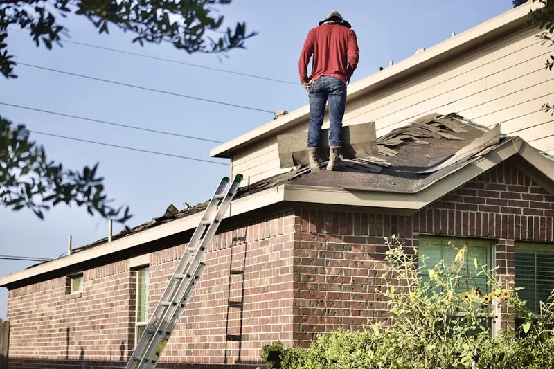 Professional roofer working on a residential roof in Brook Oaks